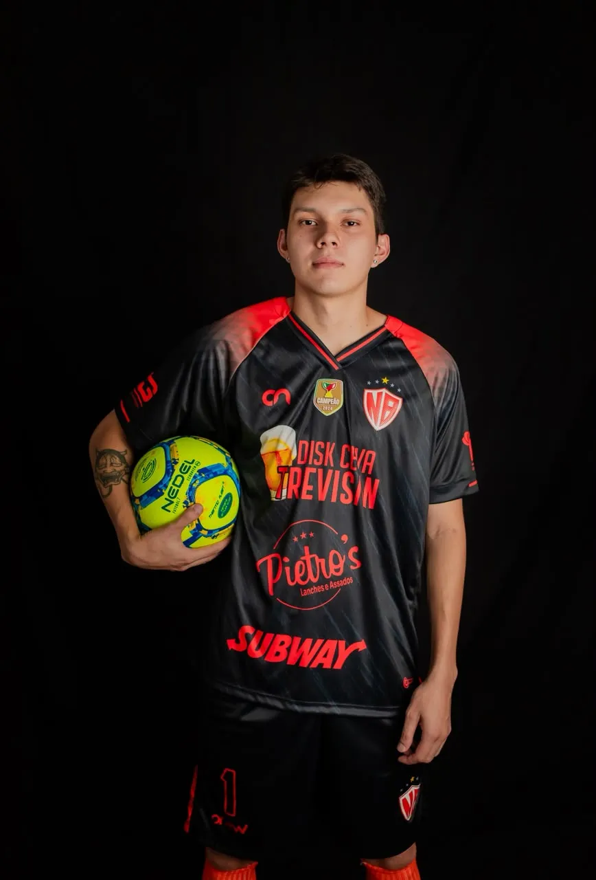 Atleta com uniforme de jogo preto e vermelho